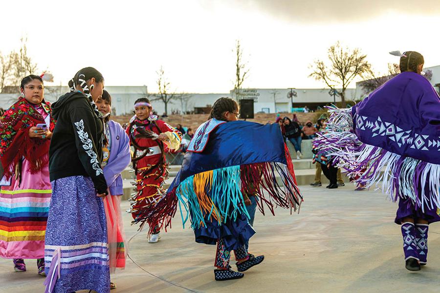 Group of women in their traditional Native American clothing performing a dance at the SJC Campus