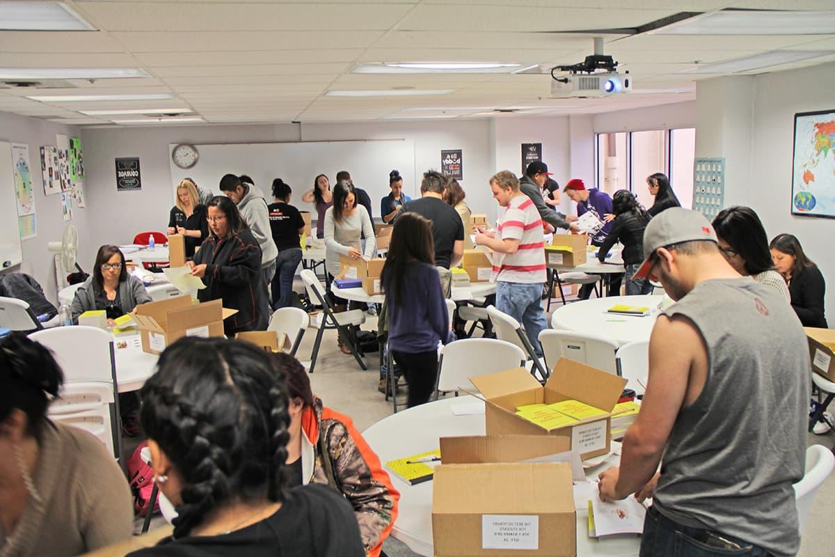 Students in the adult education program work together unpackaging and labeling all the shipments of dictionaries.